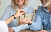 Couple close up property auction handing keys 1065757646