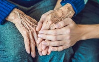 Elderly hands holding 764226022